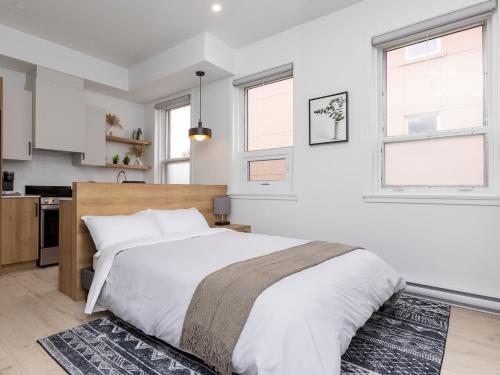 a bedroom with a large bed and two windows at Lofts Orizon in Rimouski