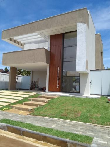 een modern huis met een rode deur bij Casa Sunset in Itacaré