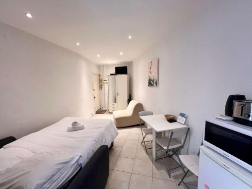 Cette petite chambre comprend un lit et une petite table. dans l'établissement A043-Functional Studio Downtown Cannes, à Cannes