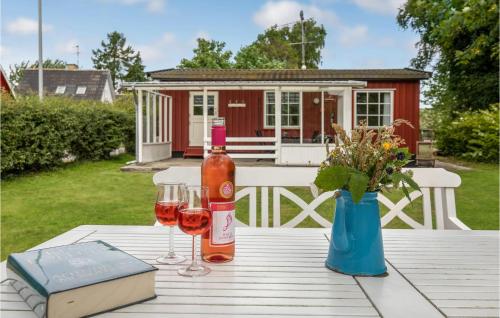 a table with two glasses of wine and a book at Two-Bedroom Holiday Home In Nexo in Neksø