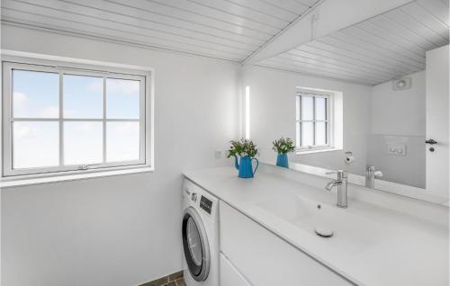 a white bathroom with a washing machine and a sink at Two-Bedroom Holiday Home In Nexo in Neksø