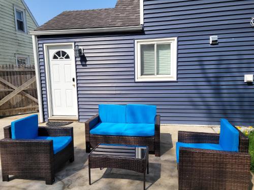 a group of blue chairs and tables on a patio at Nice house with private parking, king bed fenced yard in West Seneca