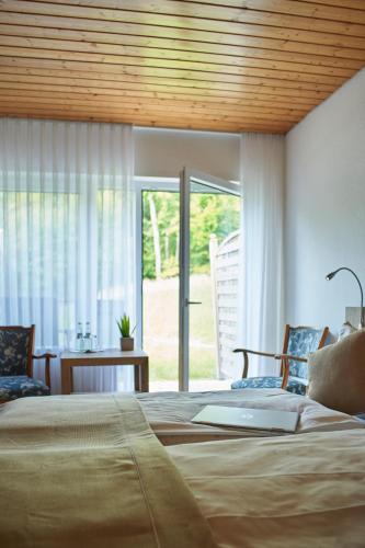 a bedroom with two beds and a sliding glass door at Hotel Restaurant Waldschlößchen in Lienen