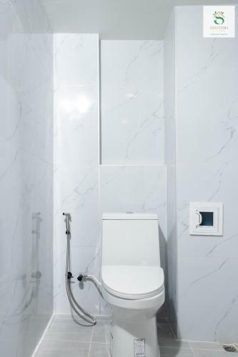 a white bathroom with a toilet and a shower at Sripoom House 1 in Chiang Mai