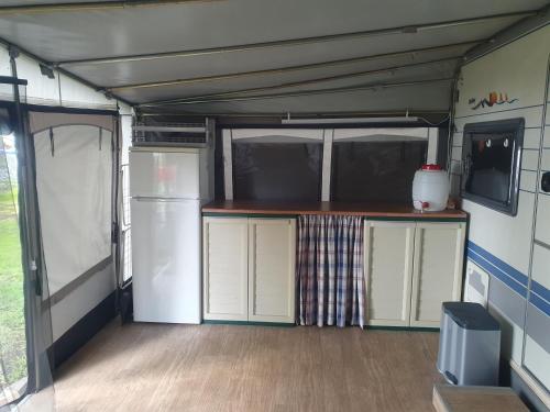 an interior of an rv with a kitchen and refrigerator at Ferienhof-Havelblick in Ketzin