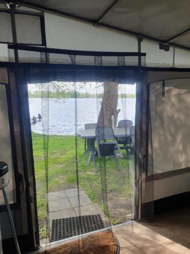 a screened in porch with a view of the water at Ferienhof-Havelblick in Ketzin