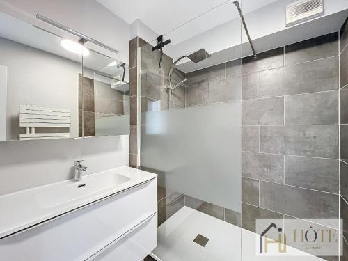 une salle de bain avec un lavabo et une douche dans l'établissement Le Panoramique Marin- 2Ch, à Bray-Dunes