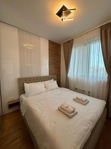 a bedroom with a white bed with two towels on it at Zlatiborske terase Spa&Wellness in Zlatibor