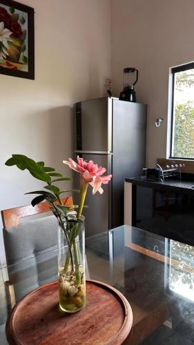 a vase with a pink flower sitting on a table at Vila Verde in Palmeiras