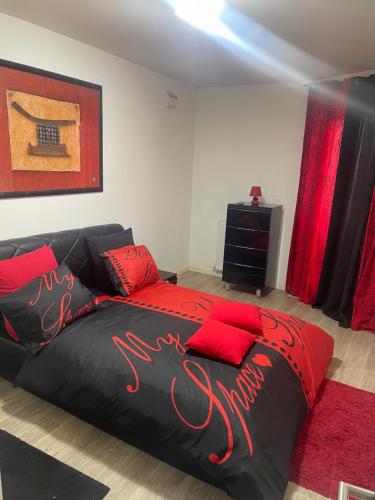 - une chambre avec un lit noir et des oreillers rouges dans l'établissement Rivadour, à Bayonne
