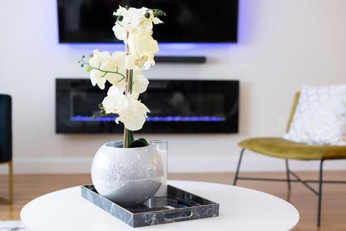 a vase with white flowers on a table at The Charles-South Shore in Randolph