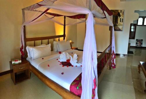 a bedroom with a large bed with a canopy at Pamas Boutique Hotel in Michamvi