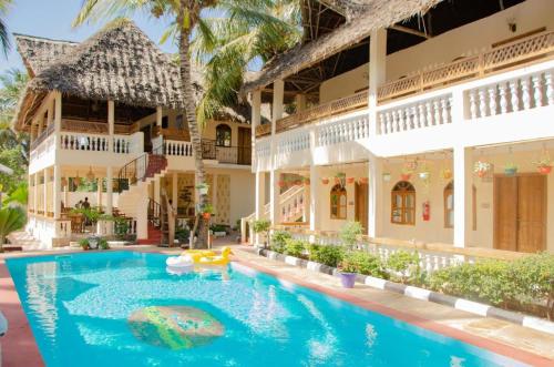 a swimming pool in front of a building at Pamas Boutique Hotel in Michamvi