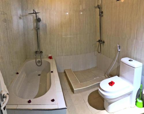 a bathroom with a toilet and a bath tub at Pamas Boutique Hotel in Michamvi