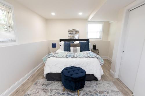 a bedroom with a bed with a blue ottoman at The Charles-South Shore in Randolph