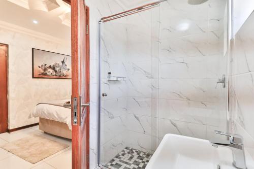 a bathroom with a shower and a sink at Lefatshe La Rona Guesthouse in Springs
