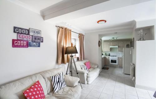 un salon avec un canapé blanc et une cuisine dans l'établissement Cozy Home In Savignac-Sur-Leyze, à Savignac-sur-Leyze