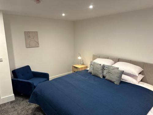 a bedroom with a blue bed and a blue chair at Comfy 2-Bed Near Nottingham & Derby, Free Parking! in Long Eaton