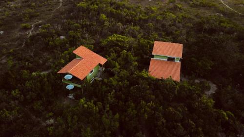 a house with an orange roof on top of a forest at Vila Verde in Palmeiras