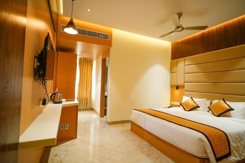 a hotel room with a bed and a television at Hotel Nakshathra- A Royal Stay in Palani