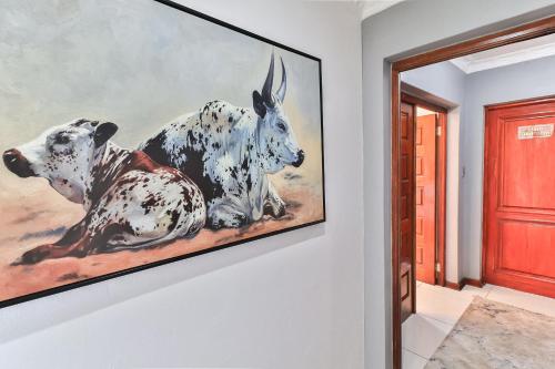 a painting of two cows on a wall at Lefatshe La Rona Guesthouse in Springs