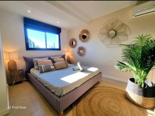 une chambre avec un lit et une plante en pot dans l'établissement L'ecrin d'Andréa - à 20min de la mer et 5min du centre, parking privé - By AURAconciergerie, à Saint-Cyr-sur-Mer
