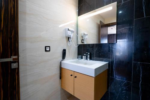 a bathroom with a sink and a mirror at Razane Hôtel in Kenitra