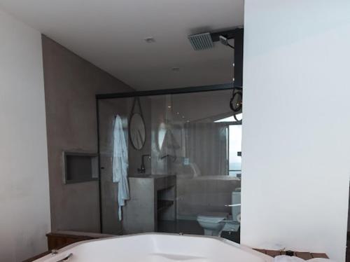 a bathroom with a tub and a toilet and a mirror at Pousada Dona Pedra - Cabana Opala in Córrego do Bom Jesus
