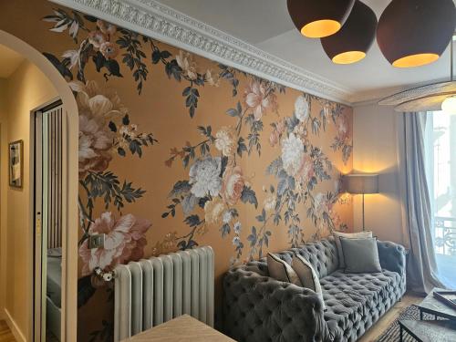 - un salon avec un canapé et du papier peint floral dans l'établissement Chic Apartment By Capucine - Grands Magasins, à Paris