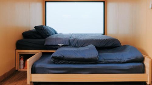 three blue pillows sitting on a bed in a room at Bobocabin Madasari, Pangandaran in Bulakbenda