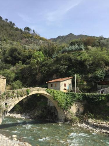 a stone bridge over a river in a mountain at La Casa di Colombetta in Badalucco