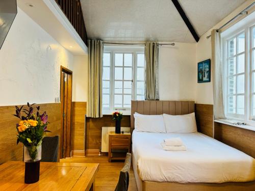 a bedroom with a bed and a table with flowers at Berkley Apartments in London