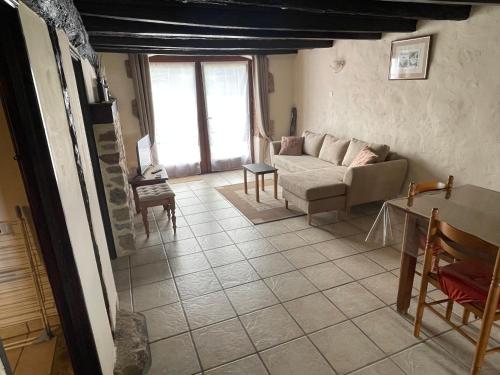 a living room with a couch and a table at Domaine Pâquerettes et Pïssenlits in Le Pommier