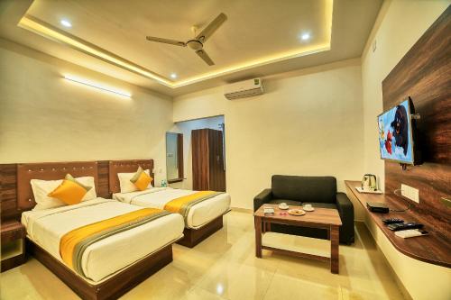 ein Hotelzimmer mit einem Bett, einem Stuhl und einem Fernseher in der Unterkunft Hotel Visa Inn 4kms from Airport l Free Airport pickup & drop 24x7 in Bangalore