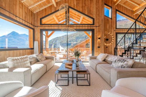 un salon avec des canapés et une table dans l'établissement Chalet JERI Spa Piscine Serre Chevalier, à Briançon