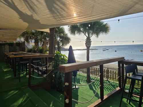 a view of the beach from a restaurant with tables and chairs at Hotel Patricia in Torreguadiaro