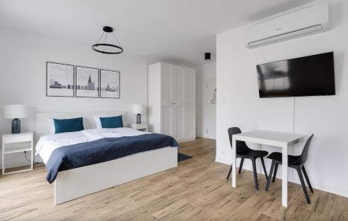 a bedroom with a bed and a table and a tv at Poznań Apartments Towarowa in Poznań