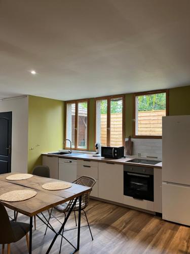 - une cuisine avec une table, une table et des chaises dans l'établissement Charmante Maison, à Ardentes