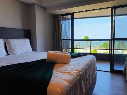 En eller flere senge i et værelse på Flat Luxo Frente Mar com Vista Espetacular