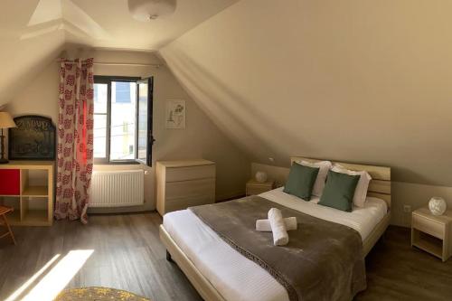 une chambre avec un grand lit avec une fenêtre dans l'établissement Bel appartement en plein centre de Cabourg, à Cabourg