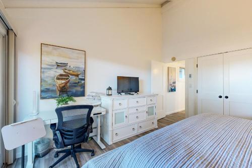a bedroom with a bed and a desk with a computer at Rita's-by-the-Sea in Moss Landing