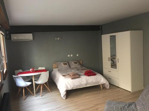 a bedroom with a bed and a table and chairs at Grande Chambre Climatisée 1 à 4 couchages in Wasselonne