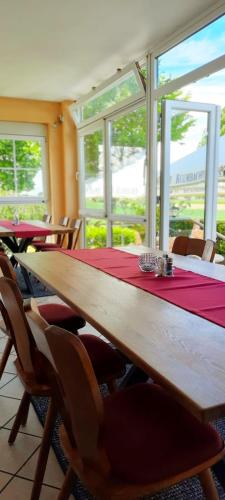 a dining room with a long wooden table and chairs at Zur Turmstube in Dossenheim