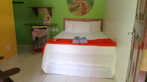 a bedroom with a bed with two shoes on it at Pousada Recanto Sapoti in Barreirinhas
