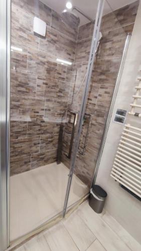 une douche avec une porte vitrée dans une salle de bain dans l'établissement Spacieux T5, 3 chambres - Vue mer panoramique sur La Rade de Toulon, à Toulon