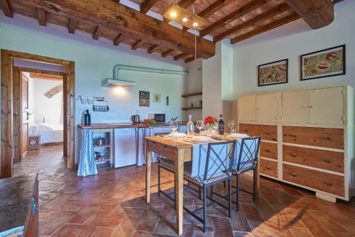 a kitchen with a table and chairs in a room at Casa Vacanze Le Fornaci in Laterina