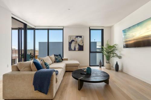 a living room with a couch and a table at The Sapphire Nest - Spectacular Rooftop Amenities Ocean views 2BR in Los Angeles