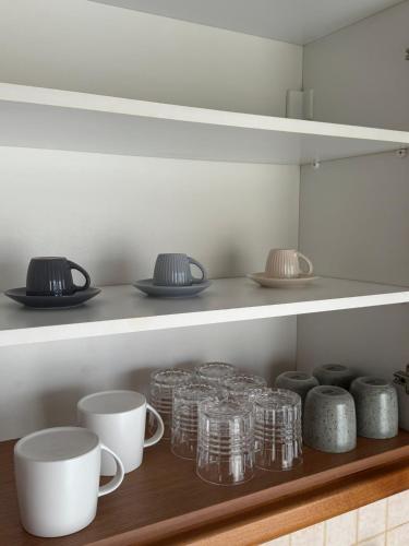 a shelf with cups and bowls on it in a kitchen at Nook 37 in Néa Ankhíalos