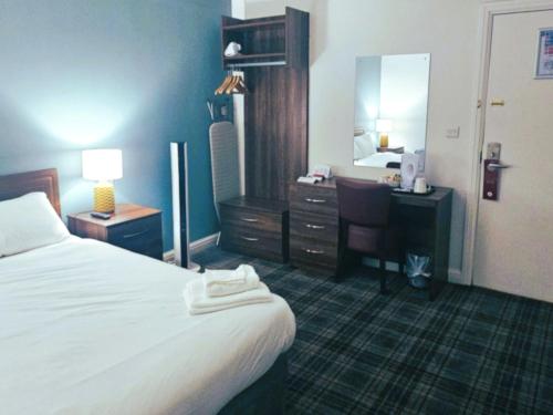 a hotel room with a bed and a desk and a mirror at Hampstead Britannia in London
