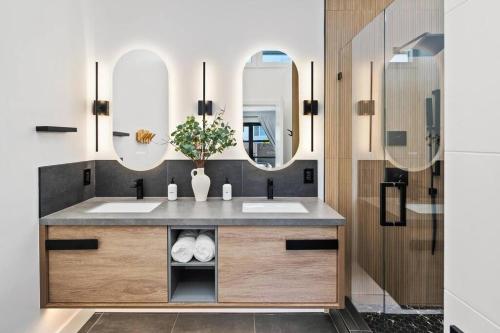 a bathroom with two sinks and two mirrors at Ventana Vista, Ocean View in San Diego